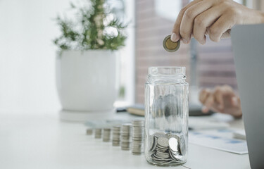 Financial business man with coins put in a jar.