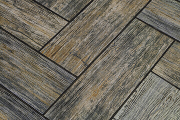 Detail of floor tiles with embossed wood texture. Brown flooring close-up.