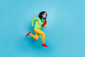 Full size profile side photo of brunette messy tails haired girl jump run empty space wear yellow...