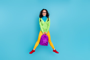 Fototapeta na wymiar Full length photo of happy funky charming girl jump up air hold backpack weekend isolated on blue color background