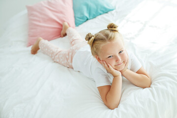 Nice baby girl enjoys a sunny morning. Good morning at home. The girl wakes up from sleep. High quality photo.