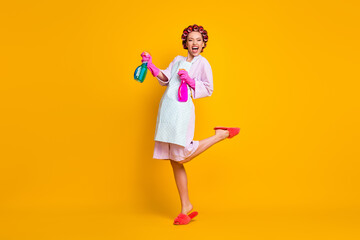 Full length body size view of pretty cheerful overjoyed maid jumping using sanitizer isolated on bright yellow color background