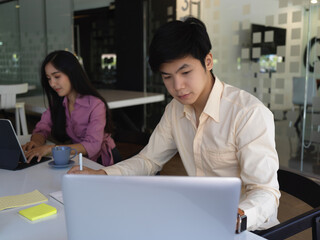 Obraz premium Businessman working laptop in meeting room with his coworker