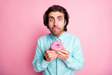 Photo of tricky sly arabian guy hold round donut cake wanna taste dessert stick tongue isolated pink color background - obrazy, fototapety, plakaty