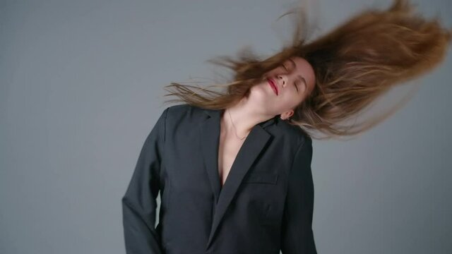Slow motion shooting of shaking hair woman in black jacket oversize