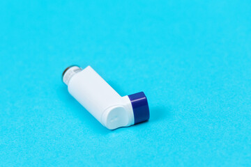 Medicine for asthma. The inhaler with the medicine is on a blue background. Copy space