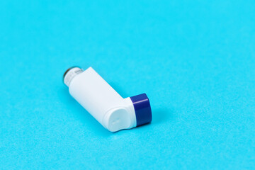 Medicine for asthma. The inhaler with the medicine is on a blue background. Copy space