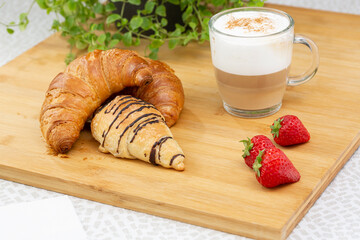 Set of croissants with a cup of cappuccino in studio.