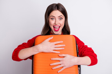 Photo portrait of happy cheerful girl embracing suitcase ready to travel smiling isolated on pastel...