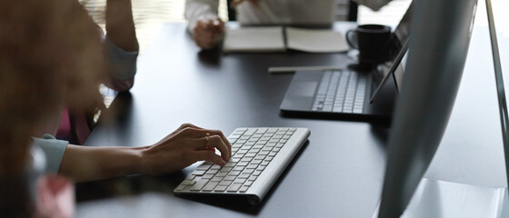 Fototapeta na wymiar Female hand typing on computer keyboard on worktable in meeting room