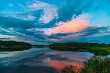 Fototapeta na wymiar Sunset light in the sky over the lake in the East in summer