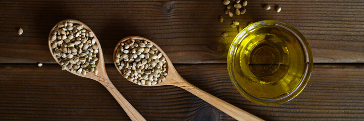 organic dried hemp food seeds in a composition with kitchen objects on a wooden background. flat...