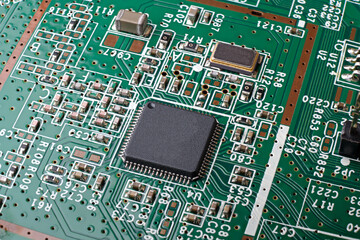 SMD microchip without marking on green PCB with a lot of surface mount chip resistors and capacitors. High depth of field.