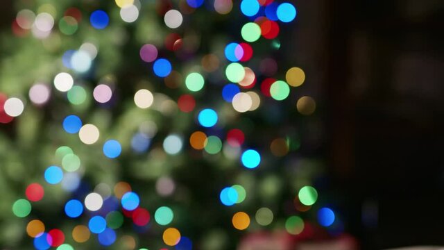 Christmas lights and tree out of focus. Moving video background.