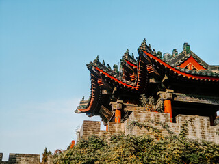 Low angle shot of a building surrounded by greenery in the Millennium city park in Kaifeng, China