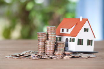 Stacks of dollar coins and house model