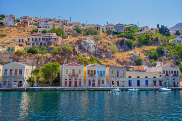 Obraz premium View of beautiful bay with colorful houses on the hillside of the island of Symi. Greece