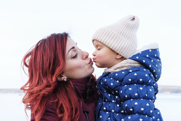 Mom kisses a little daughter - Single mom hugs a little girl - Happy mom and daughter relationship, kiss on the lips - Happy family relationship concept