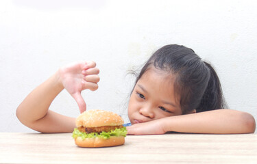 little child with homemade gourmet burger on wooden, junk food and unhealthy