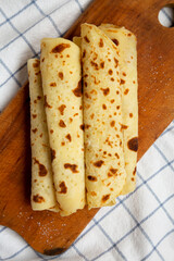 Homemade Norwegian Potato Flatbread (Lefse) with Butter and Sugar on a rustic wooden board on cloth, top view. Overhead, from above, flat lay.