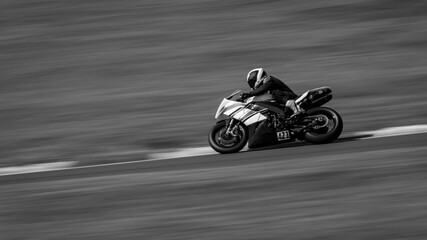 A panning shot of a racing bike cornering on a track.