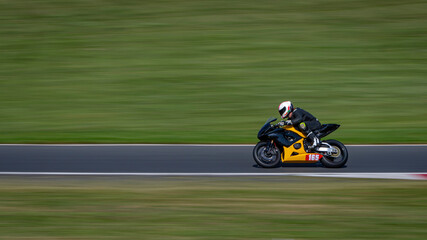 Obraz premium A panning shot of a racing bike cornering on a track.