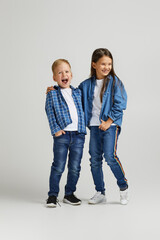 cute little boy and girl in stylish denim clothes. two happy children laughing and having fun
