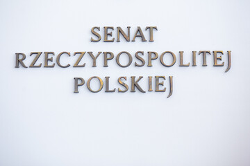 Senat Rzeczypospolitej Polskiej logo herb z flagami Polski i Unii Europejskiej na tle białej ściany - obrazy, fototapety, plakaty
