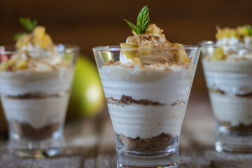 Mango mousse in glass cup with mint on wooden background