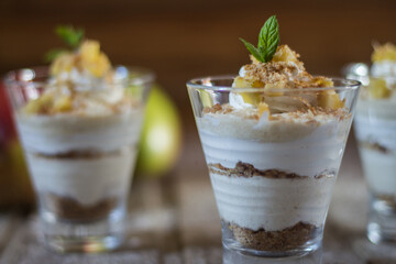 Mango mousse in glass cup with mint on wooden background