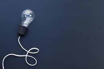 Light bulb on dark background. Ideas and creative thinking concept. Top view
