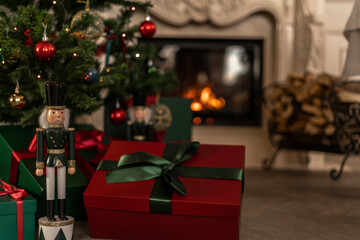 Christmas nutcracker with red gift box with fireplace on background
