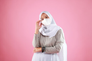 Young beautiful Asian woman wear protective face mask in prevention against Coronavirus epidemic isolated on pink background.