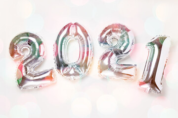 Silver balloons in the form of numbers 2021 on white background. New year celebration. Happy New Year 2021 concepts. Bokeh effect