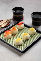 Ketan Serundeng is Indonesian Snack Made  from Sticky Rice Ball with Coconut Floss/Grated Coconut Floss. Served on Japan Plate with Tea