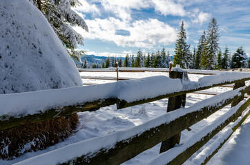 Obraz premium View to a winter landscape with wooden fence and a haystack, near to Marisel village from Cluj county, Romania.