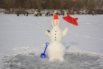 snowman with a red umbrella and a winter fishing rod, standing on a snow-covered lake