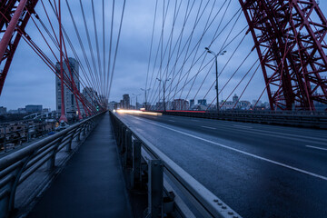 Obraz premium red cable-stayed bridge and freeway at sunrise on winter morning