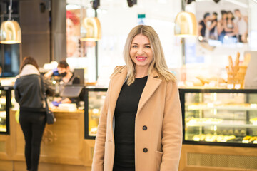 Beautiful blonde business woman in a long autumn coat