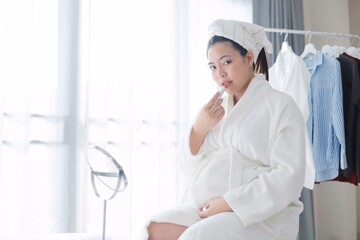 Beautiful pregnancy woman in bathrobe suit.