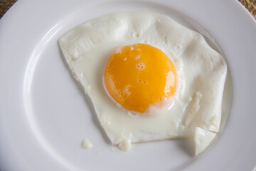 Top view of white dish with fried egg