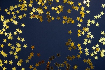Gold star confetti on a blue background with space for text. Banner, poster.