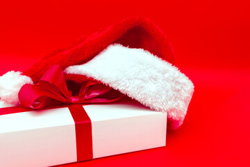Obraz na płótnie Canvas Christmas white present with santa hat closeup
