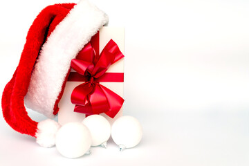 Obraz na płótnie Canvas Christmas white present with santa hat decoration balls closeup