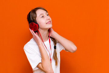 Attractive 12s girl in white t-shirt listens to music on headphones closeup