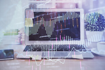 Financial chart drawing and table with computer on background. Multi exposure. Concept of...