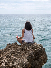 Beautiful woman practicing yoga on the beach at sunrise