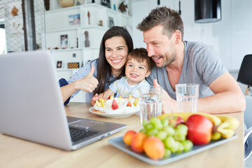 Obraz na płótnie Canvas Family celebrating birthday with child on laptop