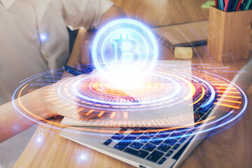 Cryptocurrency hologram, bitcoin, ico theme over hands taking notes background. Concept of blockchain. Multi exposure