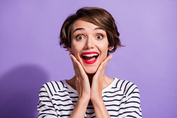 Portrait of funky impressed short brunette hairdo girl yelling hands cheeks wear stripped pullover isolated on violet background